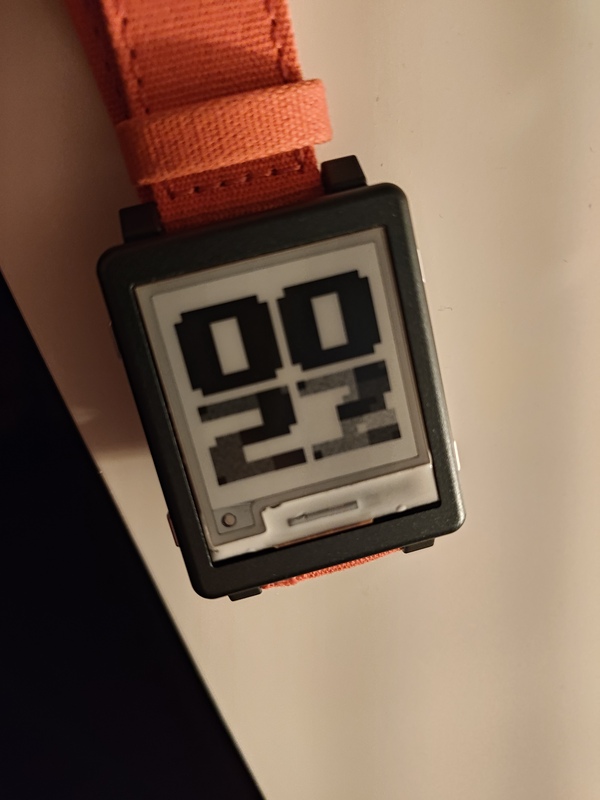 My Watchy today, with its much thinner case and an orange cloth band, running my Rust firmware and displaying very bad ghosting after a partial update